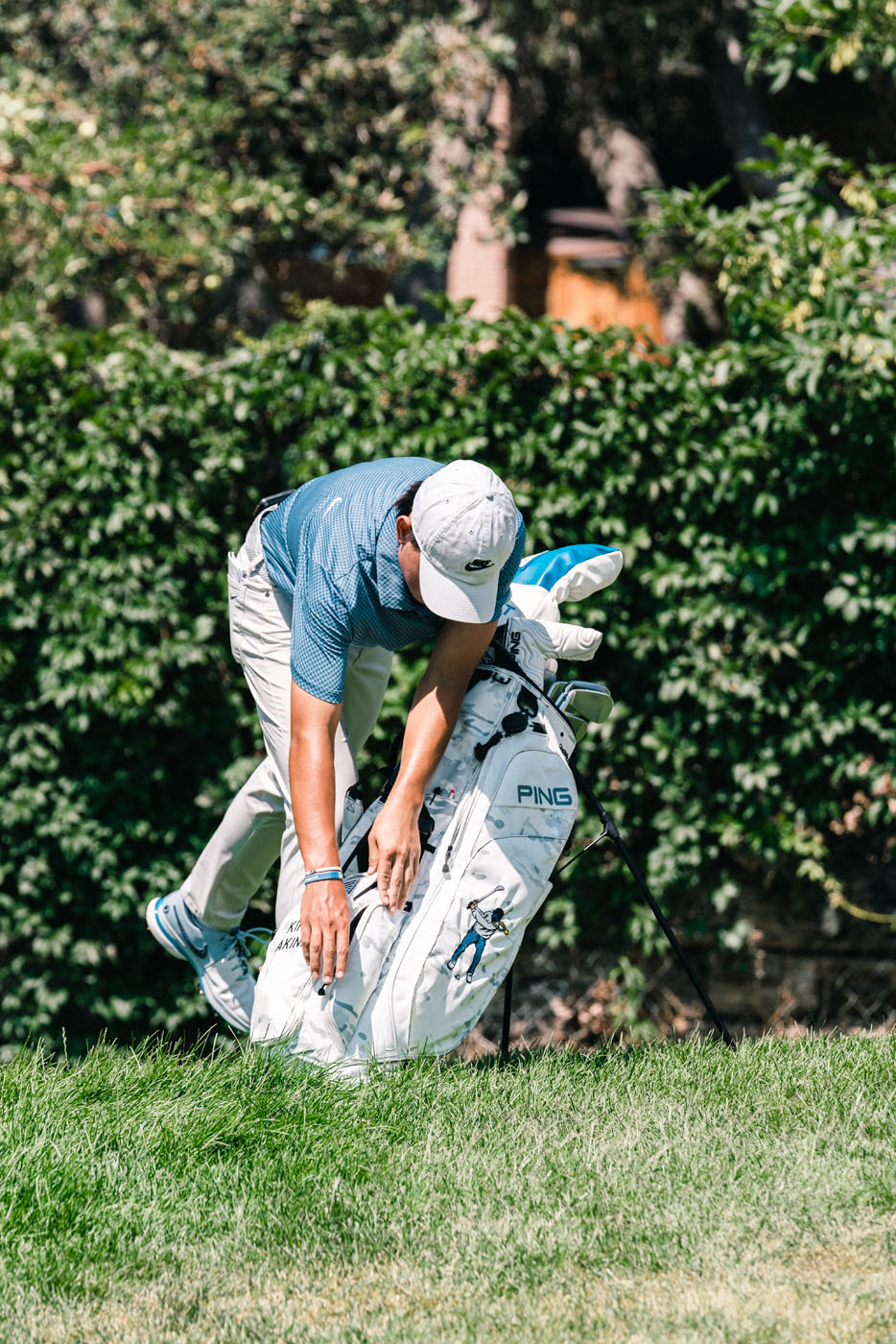 An image of a golfer bending over their custom golf bag - for Georgetown fitted golf clubs, contact Tee Box.