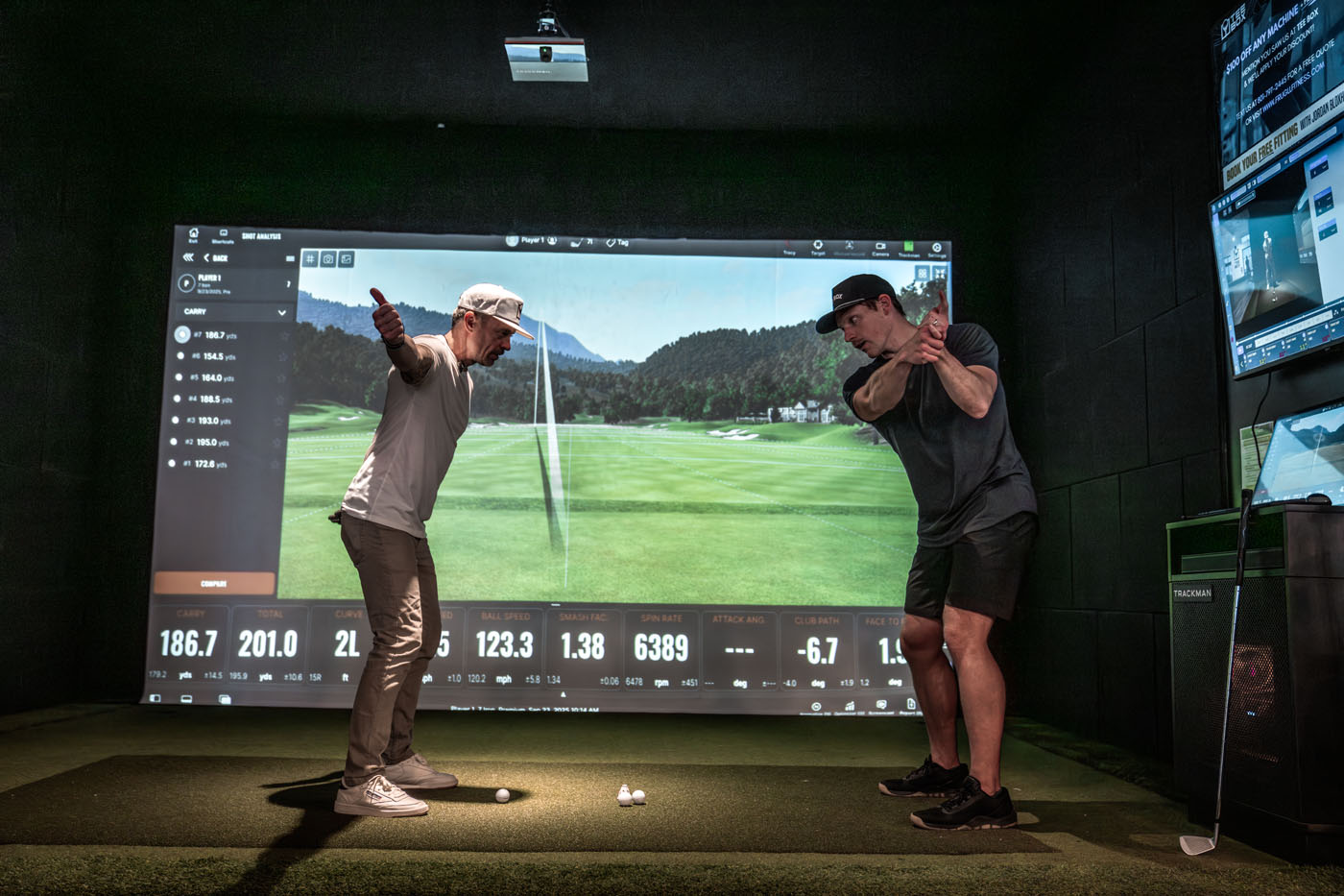 A Tee Box Pro helping a member adjust their swing based on data from TrackMan.