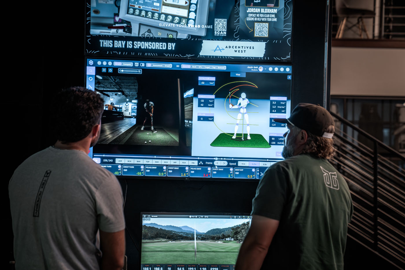 A golf pro and golfer looking at measurements from the trackman golf sim at Tee Box.