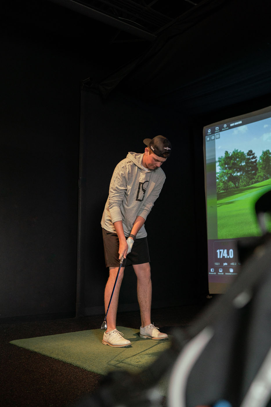 A Tee Box golfer using Trackman technology to understand their swing and other golf metrics - pro golf lessons.