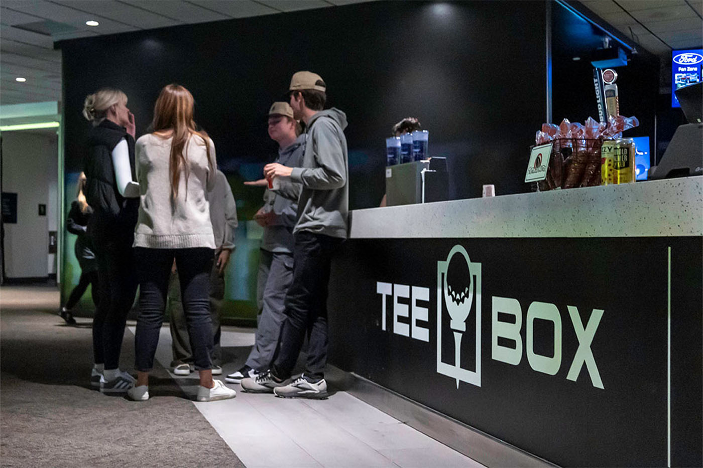 A group of Tee Box members talking at the front desk.