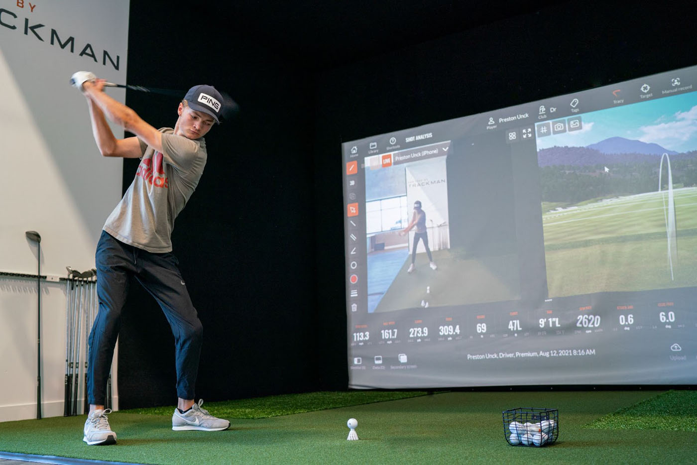 A Tee Box member practicing his golf swing on a golf trackman simulator.