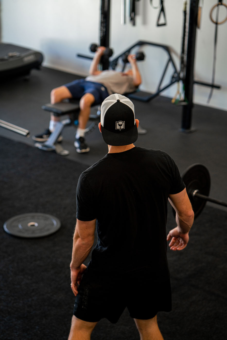 An adult golfer training with Tee Box gym equipment.